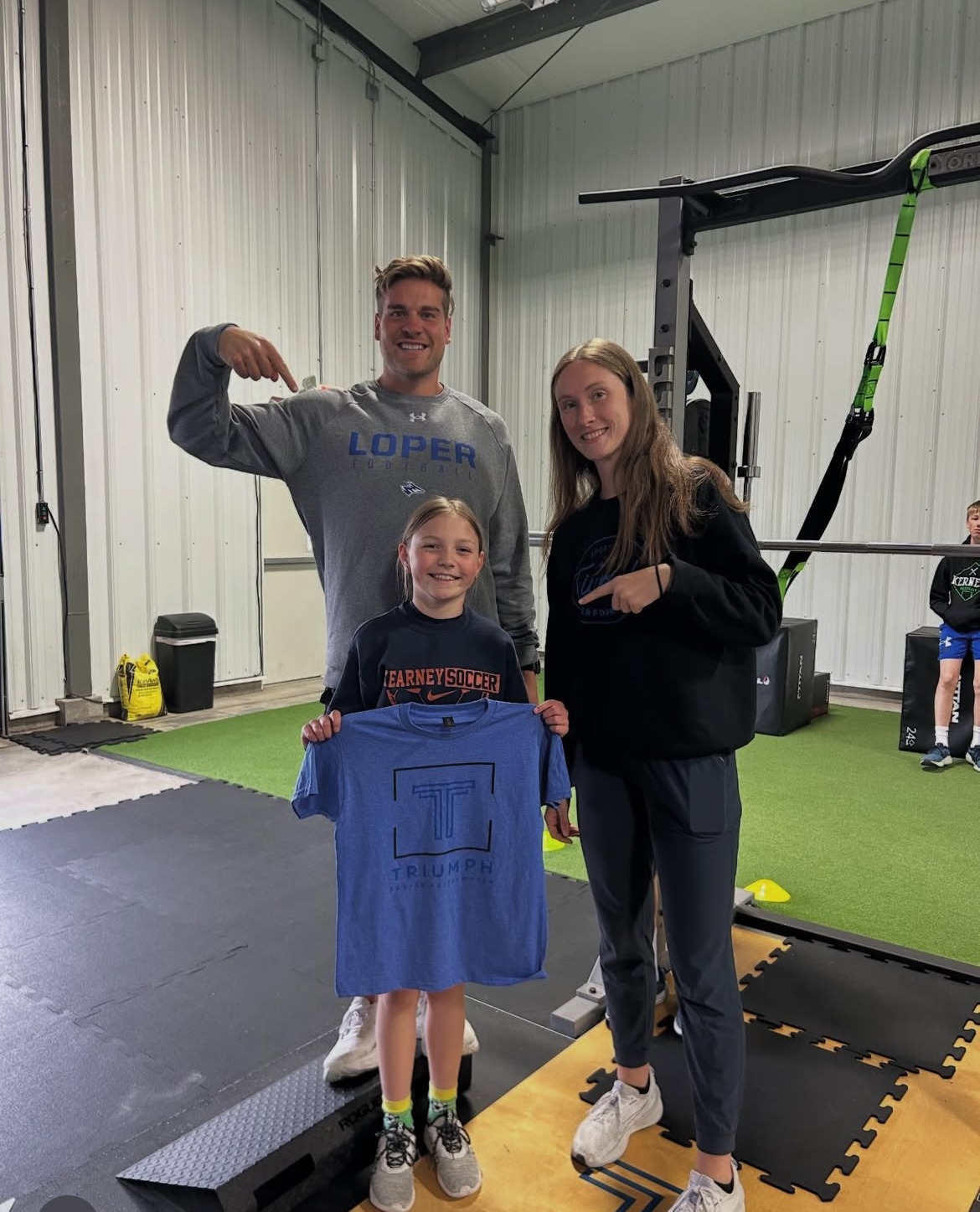 Young athlete proudly holding Triumph gear